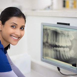 Dental assistant smiling while reviewing X-ray