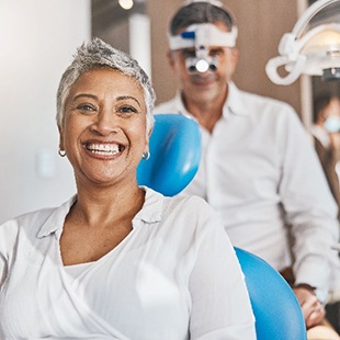 Woman smiling while sitting in dentist's treatment chair