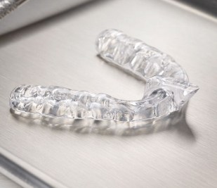 Clear mouthguard lying on gray table
