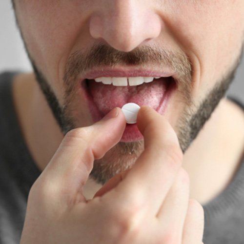 Closeup of man taking oral conscious dental sedation in Norman